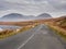 Scene in Connemara national park, Old asphalt road, sheep grazing grass, Beautiful mountains in the background. Cloudy sky