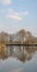 Scene of early spring on the river.Symmetric picture,reflection of trees in the water.Vertical orientation of the image