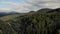 Scene of green forests in mountain under cloudy sky.