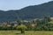 Scene with mountain top, forest, glade and residential district of bulgarian village Beli Iskar, Rila mountain