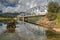 Scene of the Nisutlin Bay Bridge reflected on the water surrounded by hills in Teslin, YT, Canada