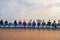 Scene with people sitting on blue chairs on promenade des Anglais at sunset time. Nice, France