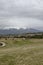 Scene with springtime mountain glade, forest, snow and residential district of bulgarian village Plana