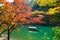 Scene with tourist boat and Hozugawa river in Arashiyama park in autumn season, Kyoto, Japan