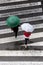 Scene of two women with fashion umbrella crossing the sidewalk. Top view