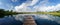 Sceneric panoramic view of the lake with a wooden pier