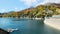 Scenery of autumn lake with boats parking by lakeside and mountains of colorful foliage by Kurobe Dam