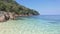 Scenery of clear crystal sea water on the beach with island of tropical forest, shade of blue sea and blue sky