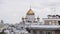 Scenery of facades of big new white high building and church on cloudy day