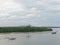 Scenery of Leam Sing estuary or river mouth with small pier and boat for local fishery and mountain in the background