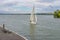 Scenery with lonely fisherman, sailboat and flying gull on a Dnepr river embankment