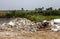 Scenery of piles of concrete debris and white tiled ceilings being dumped together