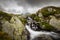 Scenery in the Romanian Alps, with stormy cloudscape and granite slabs