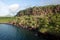 Scenery of a shore with a rocky cliff covered in green near ocean, Galapagos Islands, Ecuador