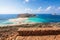 Scenery of sunny summer day with sand beach, turquoise sea and mountains. Blue horizon line. Place for tourists rest Balos lagoon.