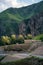 Scenery of the wriggle of mountains with rural farmhouse in sunlight