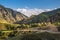 Scenery of the wriggle of mountains with rural farmhouse in sunlight