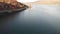 A scenic aerial backward reveal footage of Barmouth estuary with the Clock House, majestic mountain and blue water under a beautif