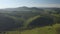 Scenic aerial panoramic view of idyllic rolling hills spring landscape in with lush green mountain pastures in evening