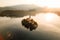 Scenic aerial shot of a small island populated with a cluster of houses on the lake Bled at sunrise