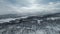 Scenic Aerial video - backward fly over snowy mountains, birch forest, frozen lake, small village. Sunny day, clouds. Subarctic