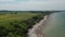 Scenic aerial view of Baltic sea shoreline in Germany, flying forward lowering down to tourist beach, day