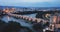 Scenic aerial view of lighted Roman bridge across Guadalquivir river and Mezquita-Catedral on background with Cordoba