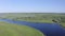 Scenic aerial view of a river and green fields in a countryside