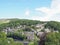 A scenic aerial view of the town of hebden bridge in west yorkshire with streets of stone houses and roads between woodland trees