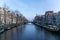 Scenic Amsterdam canal with traditional tall wonky crooked houses along the waterfront.