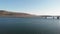 A scenic areal sideway right to left footage of the Barmouth bridge viaduc Wales with majestc mountains and blue water under a