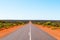 Scenic Australian outback road with red sand and bush