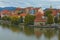 Scenic autumn landscape of Drava River, embankment and Water Tower in Maribor. Cloudy morning, mountains at the background.