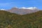 Scenic autumn landscape of Main Caucasus ridge with snowy mountain peak tops on blue sky background