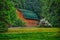 A scenic barn surrounded by trees and flowers