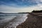 Scenic beach covered with pebbles under a cloudy sky