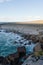 Scenic beach with an expansive body of water and rocky outcroppings along the shoreline.