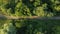 scenic bird's-eye view of dirt roads lined with trees in the countryside in summer