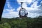 A scenic cable car with colorful cabs over mountains with green