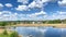 Scenic calm quiet panorama view on lake,pond,river with blue water in countryside rural village area with private houses