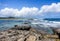 Scenic Caribbean Seascape with Blue Cloudy Sky and Rocky Coast in foreground