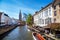 Scenic cityscape with houses, boat with tourists in Bruges, Belgium