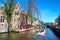 Scenic cityscape with medieval houses, boat and canal in Brugge, Belgium