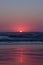 Scenic deep red sunset over Pacific Ocean, Oregon Coast. Red sun go down coloring sly and horizon in purple and red