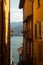 Scenic display of Como lake seen between the buildings of the narrow street of Varenna town, Italy