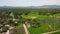 Scenic drone fly over a rural village sorrounded with green trees and rice fields