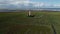 Scenic drone footage of a lighthouse in the middle of a large field