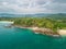 Scenic drone shot of lush palms on the rocky beach, cool for background