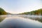 Scenic early morning fog just above the water level of Connecticut River with colorful fall foliage along both sides converging