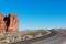 Scenic empty road in the desert sandstone rocks. Blue sky